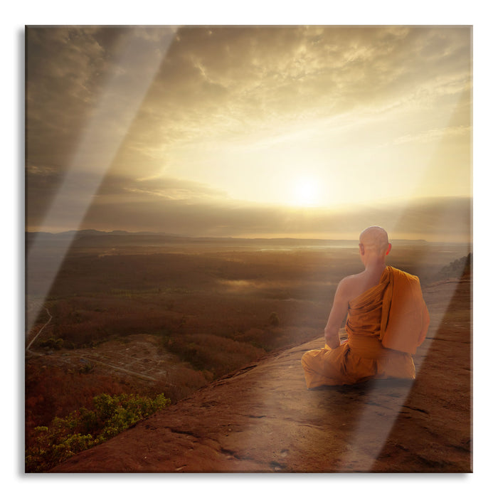 Mönch meditiert auf Felsvorsprung, Glasbild Quadratisch