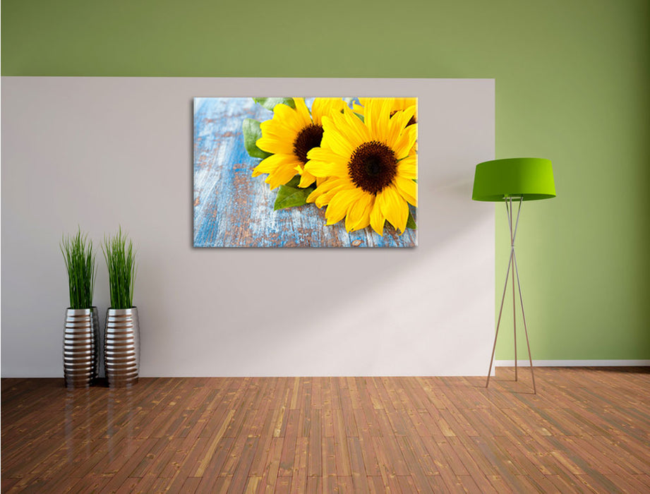 Sonnenblumen auf Holztisch Leinwandbild im Flur