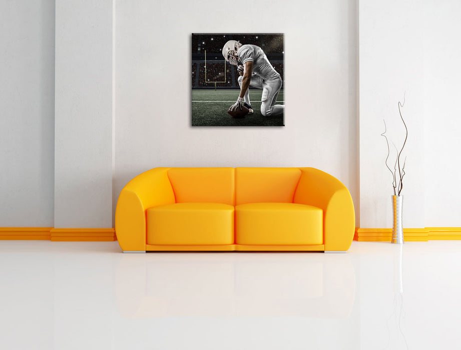 knieender Football-Spieler Leinwandbild Quadratisch über Sofa