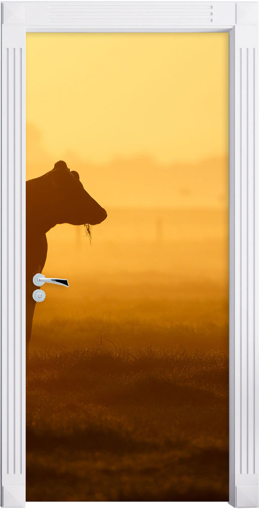 eine fressende Kuh auf der Weide Türaufkleber