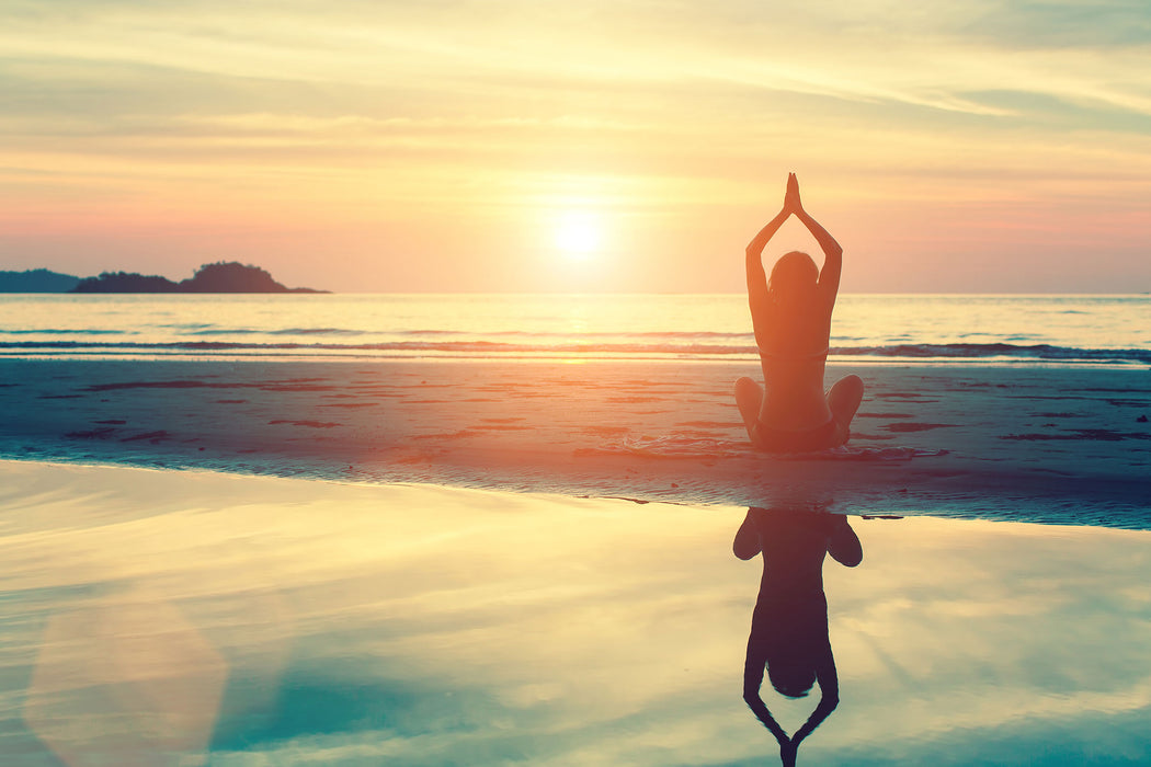 Frau in einer Yogapose am Strand, Glasbild