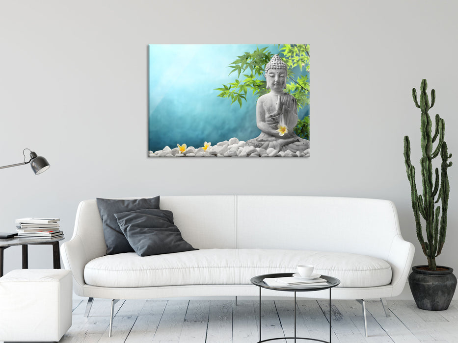 Buddha auf Steinen mit Monoi Blüte, Glasbild