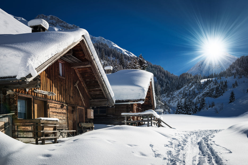 Verschneite Alpenhütte, Glasbild