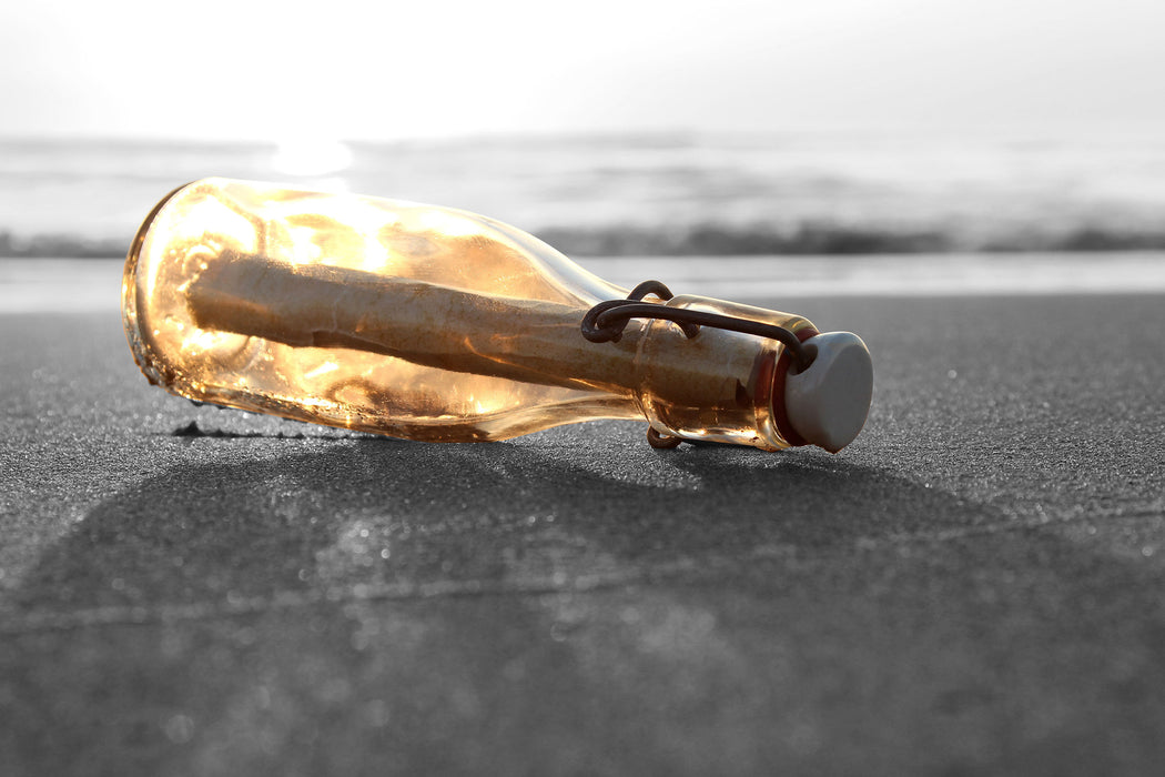 einsame Flaschenpost am Strand, Glasbild