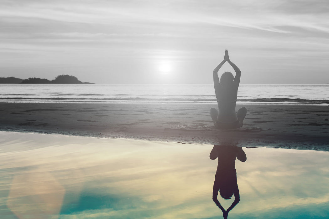 Frau in einer Yogapose am Strand, Glasbild