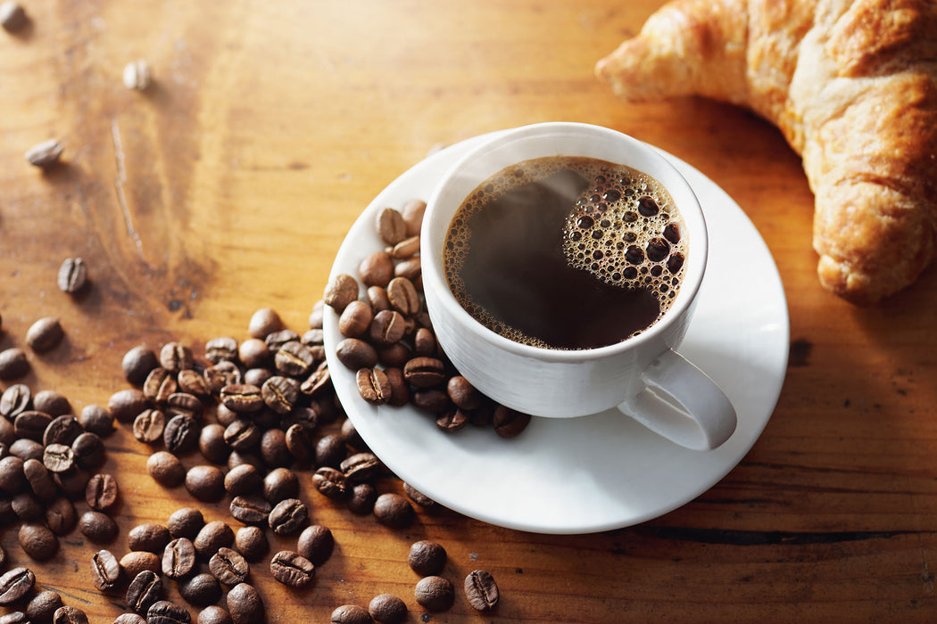 Tasse Kaffee mit Bohnen und Croissant, Glasbild