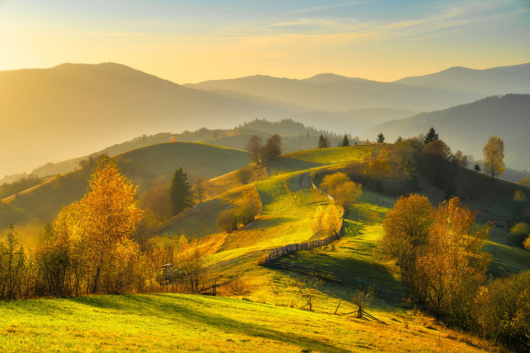 Hügelige Herbstlandschaft bei Sonnenuntergang, Glasbild