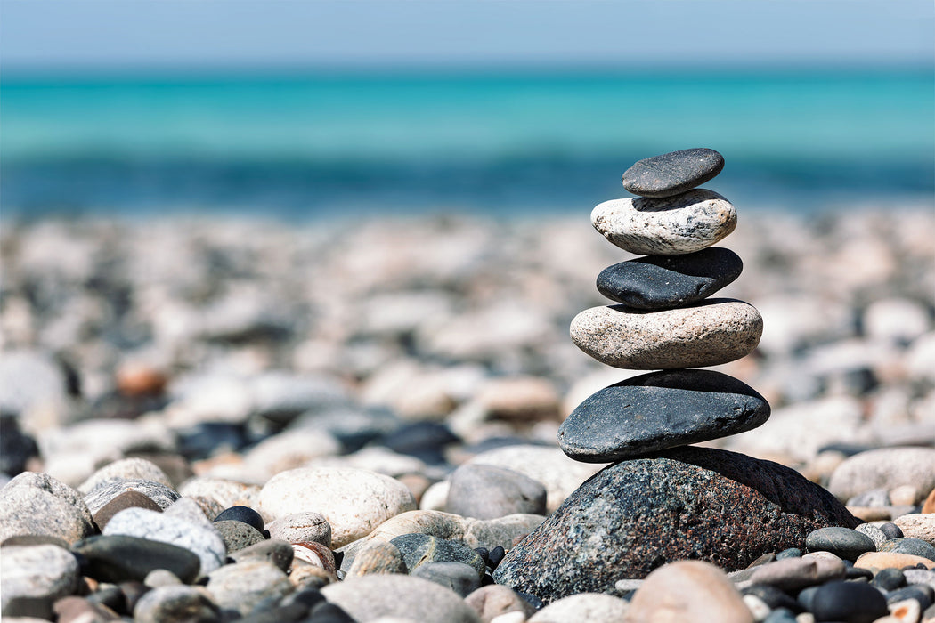 Steinpyramide am Kiesstrand, Glasbild