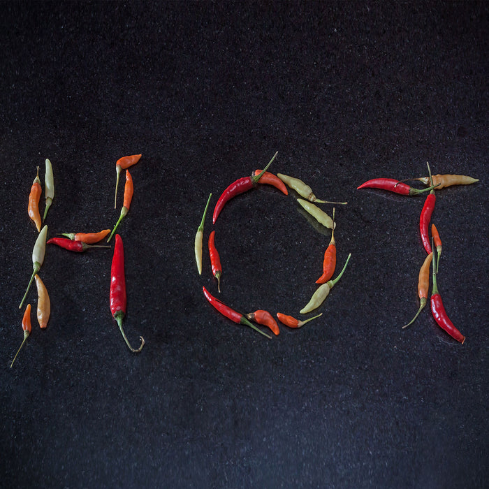 Chilis zu dem Wort Hot geformt, Glasbild Quadratisch