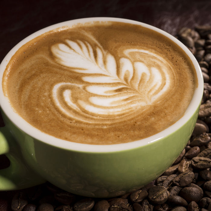 Cappucino zwischen Kaffeebohnen, Glasbild Quadratisch