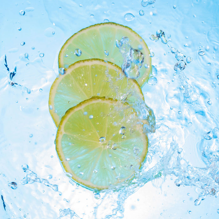 Zitrone fällt ins Wasser, Glasbild Quadratisch