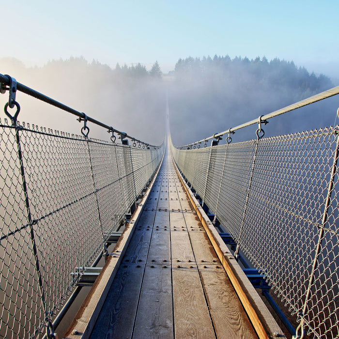 Hängeseilbrücke im Nebelschimmer, Glasbild Quadratisch