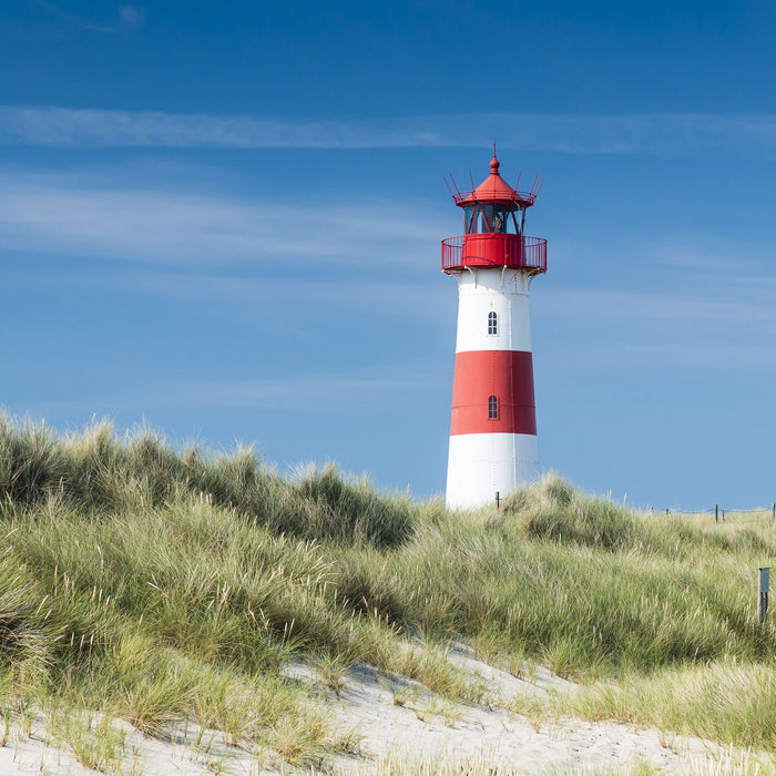 Leuchtturm hinter Dünen, Glasbild Quadratisch