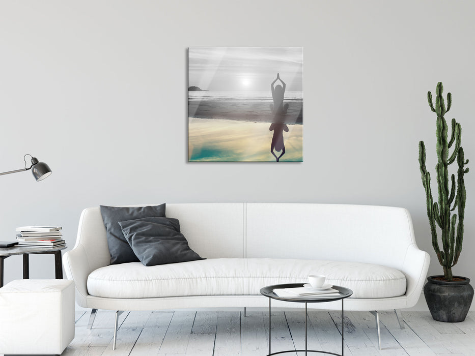 Frau in einer Yogapose am Strand, Glasbild Quadratisch