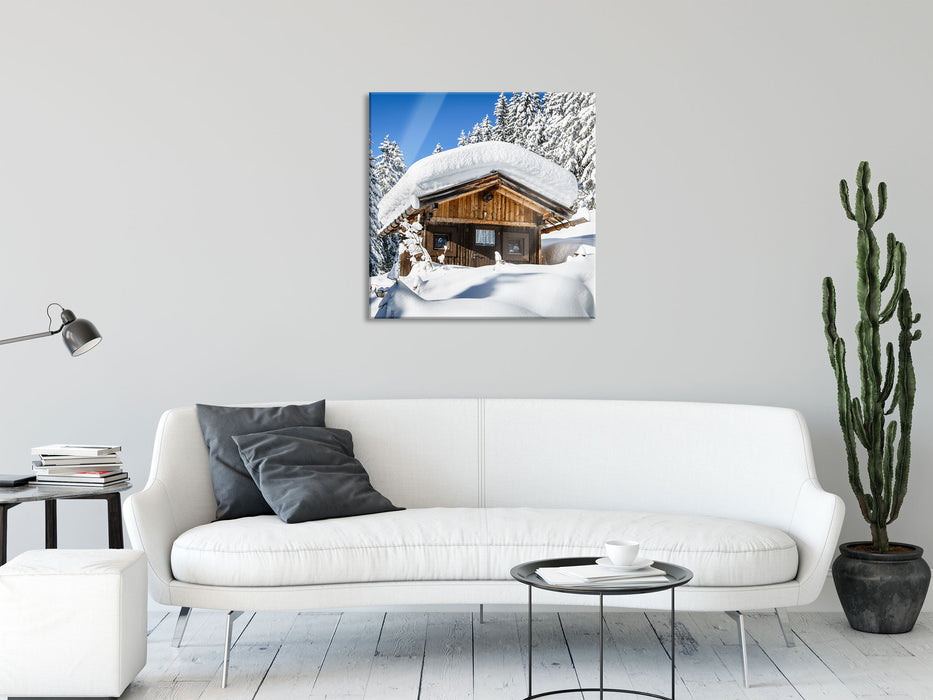 Verschneite Skihütte in Alpenwald, Glasbild Quadratisch