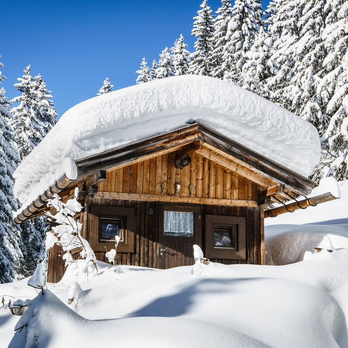 Verschneite Skihütte in Alpenwald, Glasbild Quadratisch