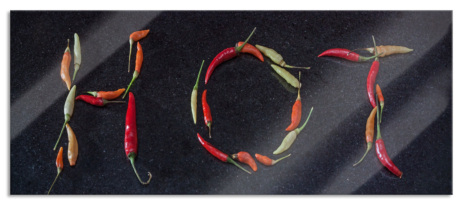 Pixxprint Chilis zu dem Wort Hot geformt, Glasbild Panorama