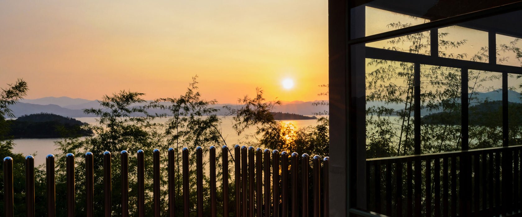 Haus am See bei Sonnenuntergang, Glasbild Panorama