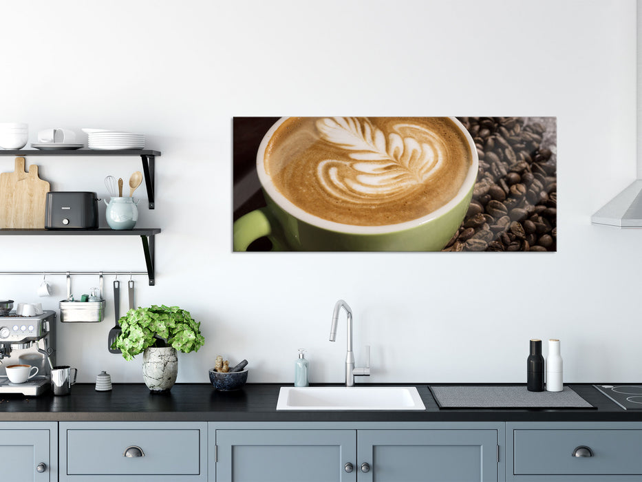 Cappucino zwischen Kaffeebohnen, Glasbild Panorama