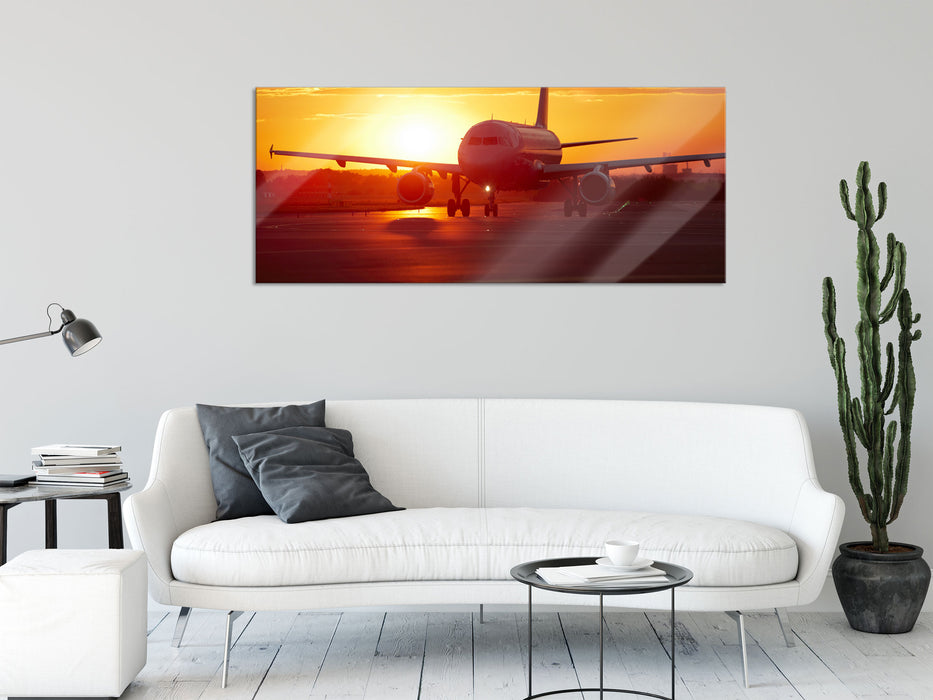 Flugzeug im Sonnenuntergang, Glasbild Panorama