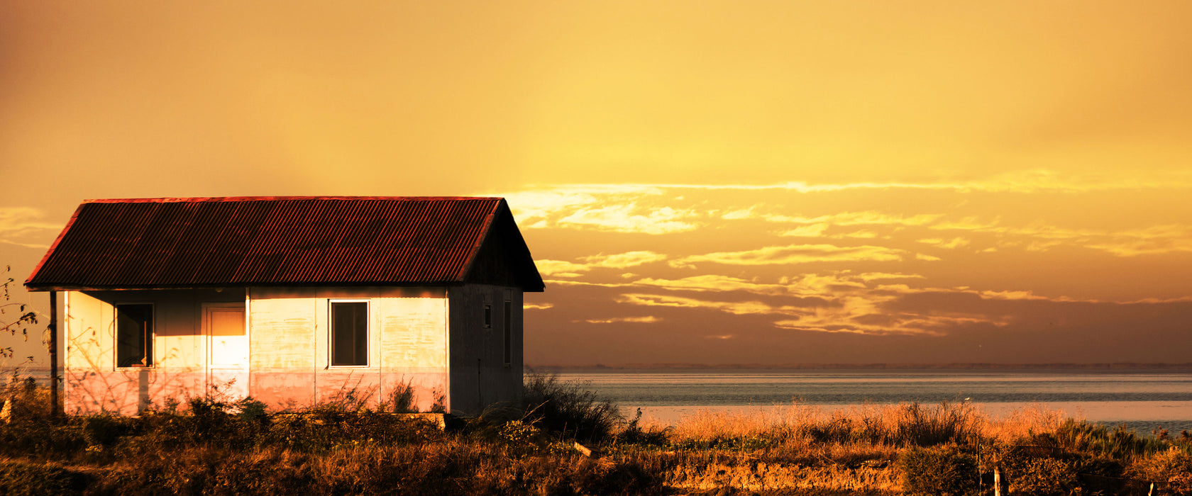 Haus am See bei Sonnenuntergang, Glasbild Panorama