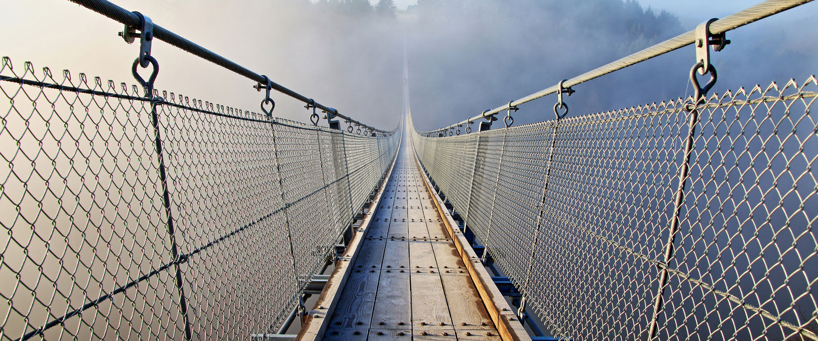 Hängeseilbrücke im Nebelschimmer, Glasbild Panorama