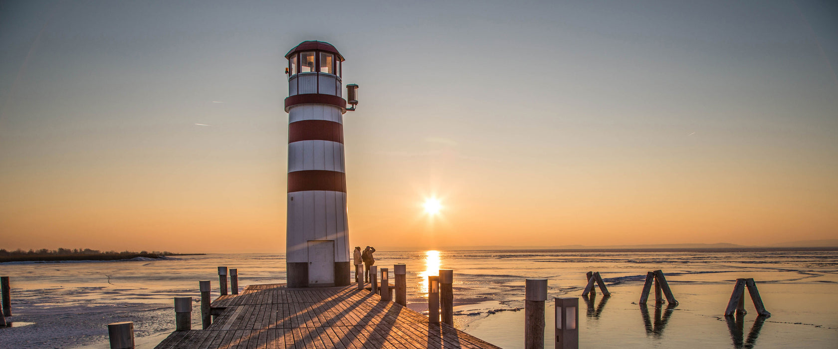 Leuchtturm im Sonnenuntergang, Glasbild Panorama