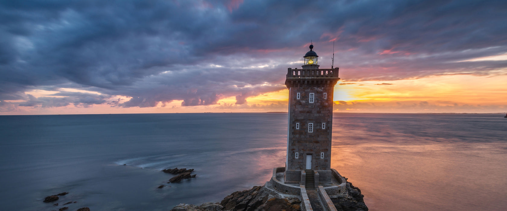 Leuchtturm im Sonnenuntergang, Glasbild Panorama