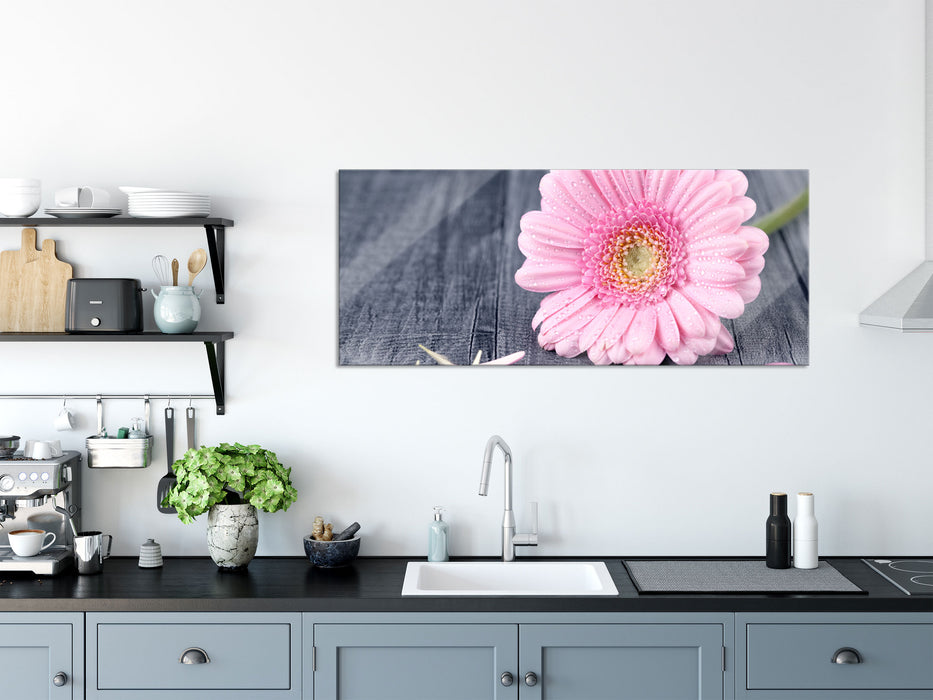 pinke Gerbera auf rustikalem Boden, Glasbild Panorama