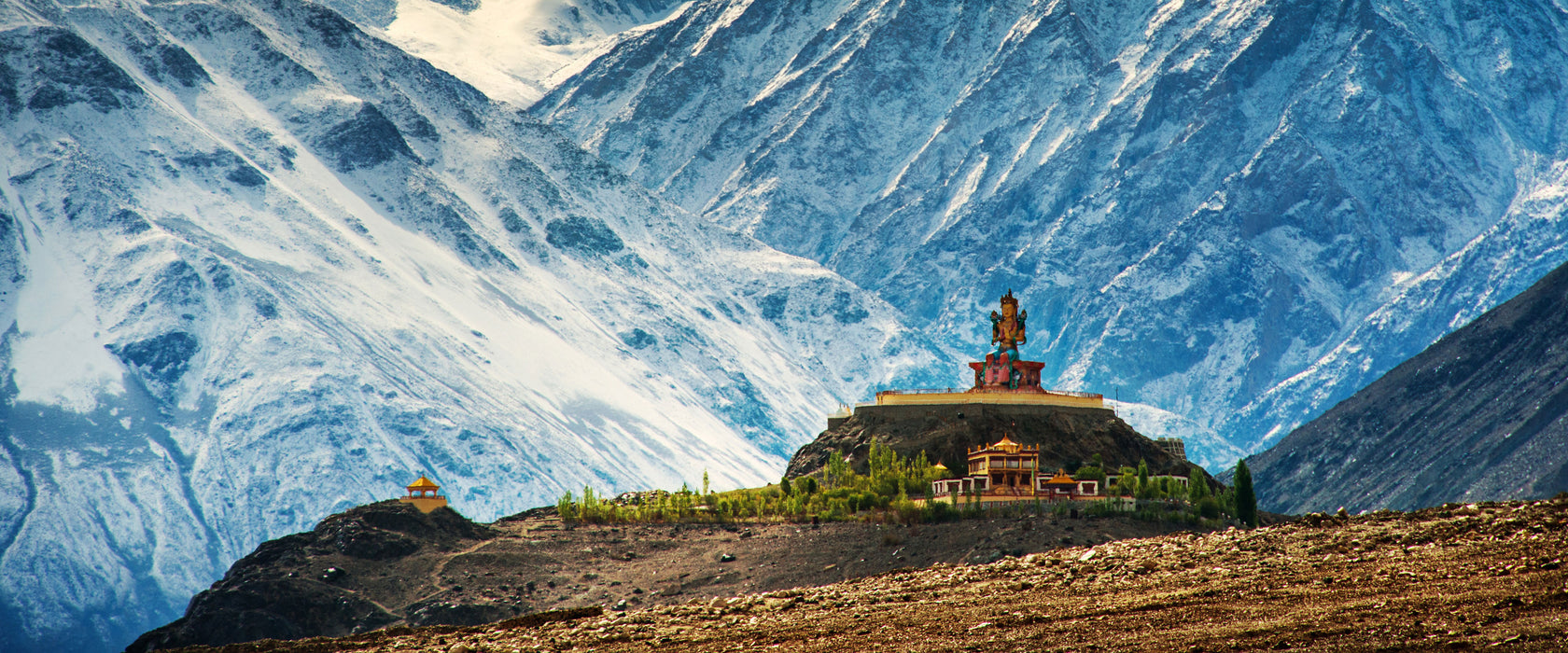 Tempel an Bergen in Tibet, Glasbild Panorama