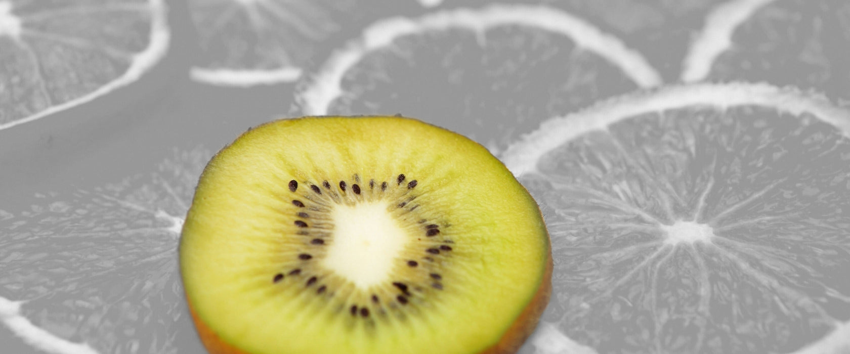 einsame Kiwi auf Orangenscheiben, Glasbild Panorama