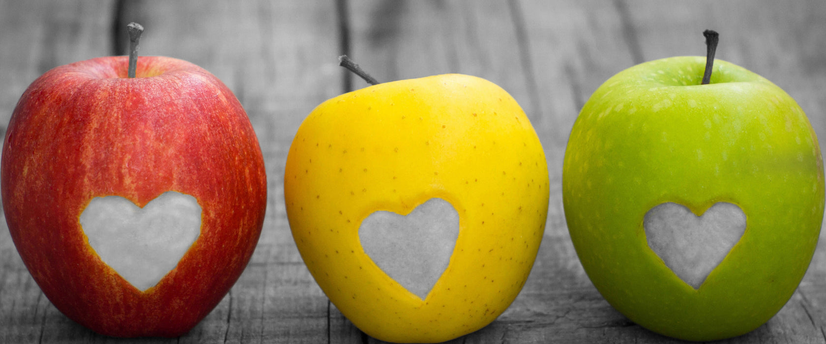 Herzäpfel auf Holztisch, Glasbild Panorama