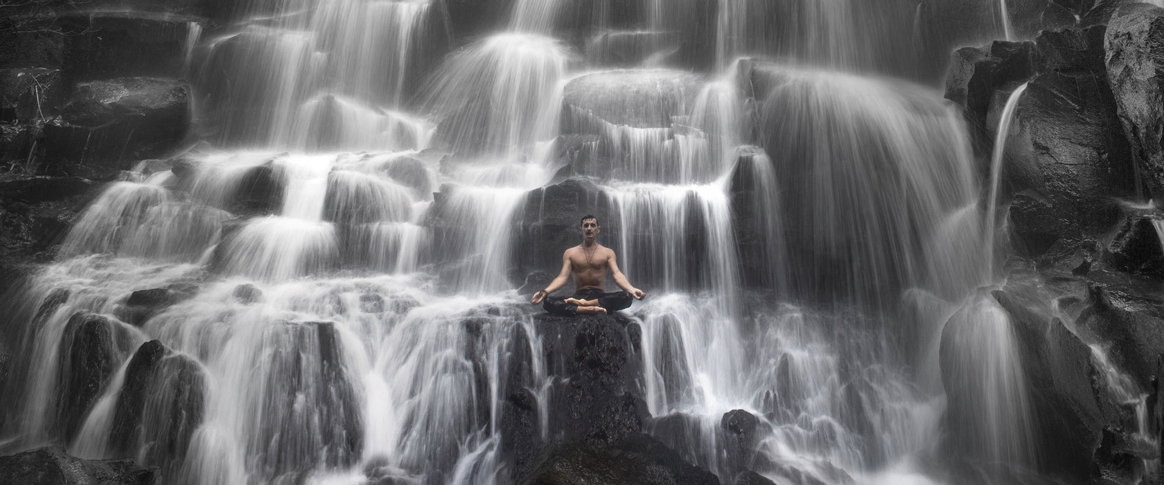 Yoga am Wasserfall in Bali, Glasbild Panorama