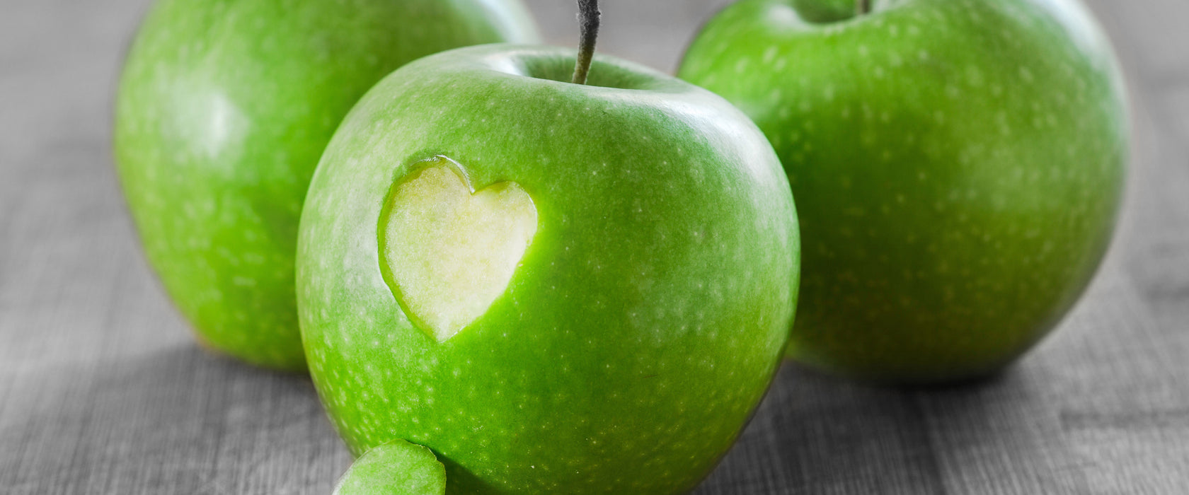 ein Herzchen im Apfel, Glasbild Panorama