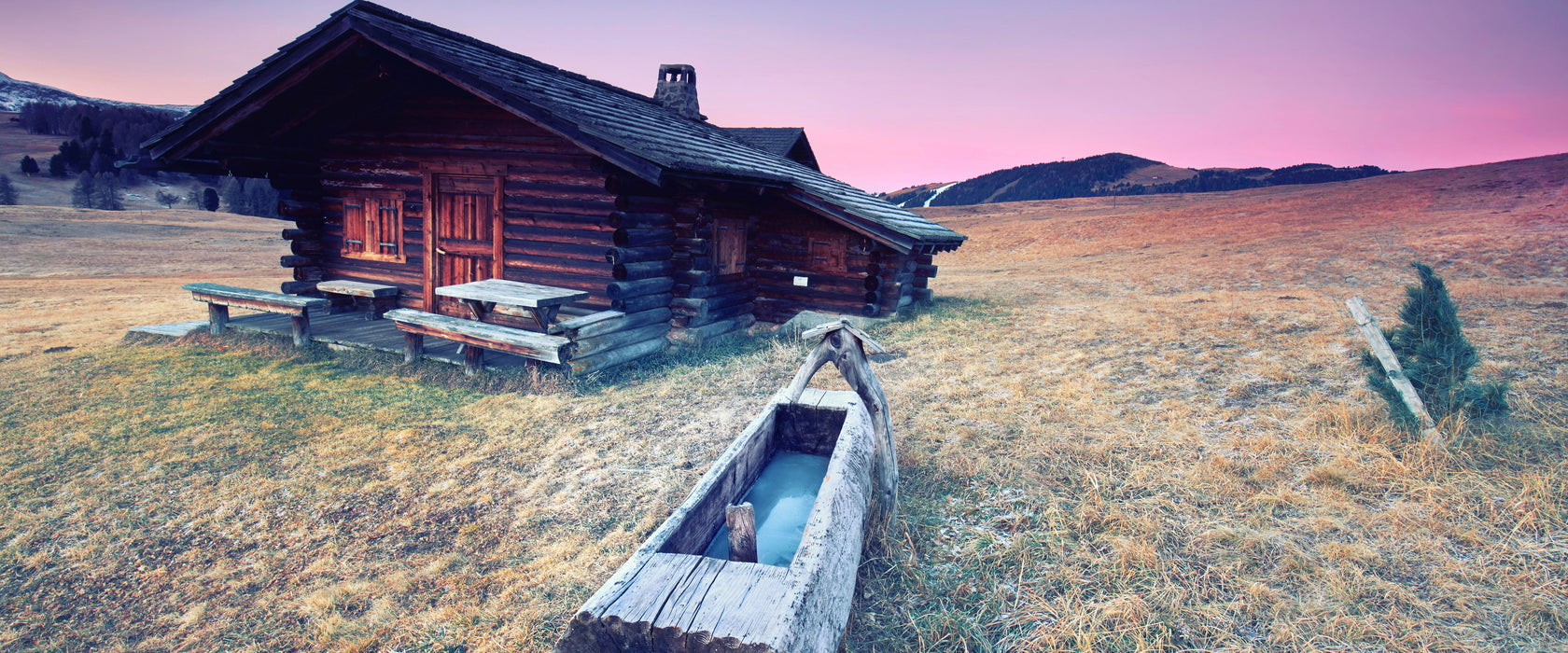 Blockhaus mit Wassertrog Dämmerung, Glasbild Panorama