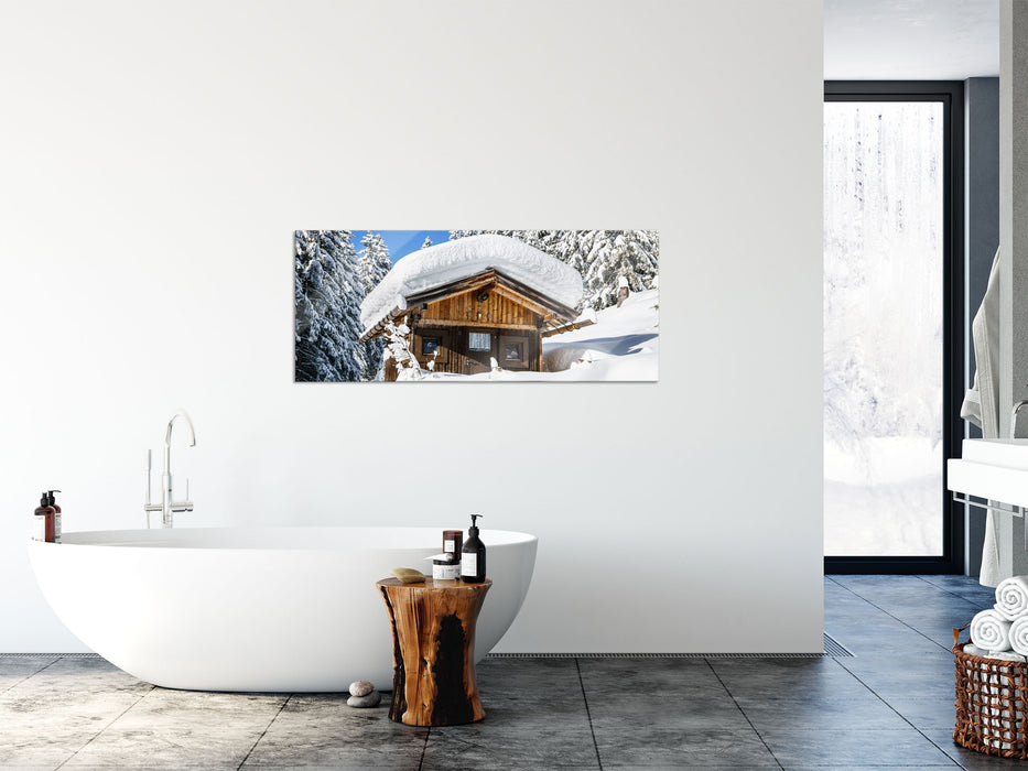 Verschneite Skihütte in Alpenwald, Glasbild Panorama