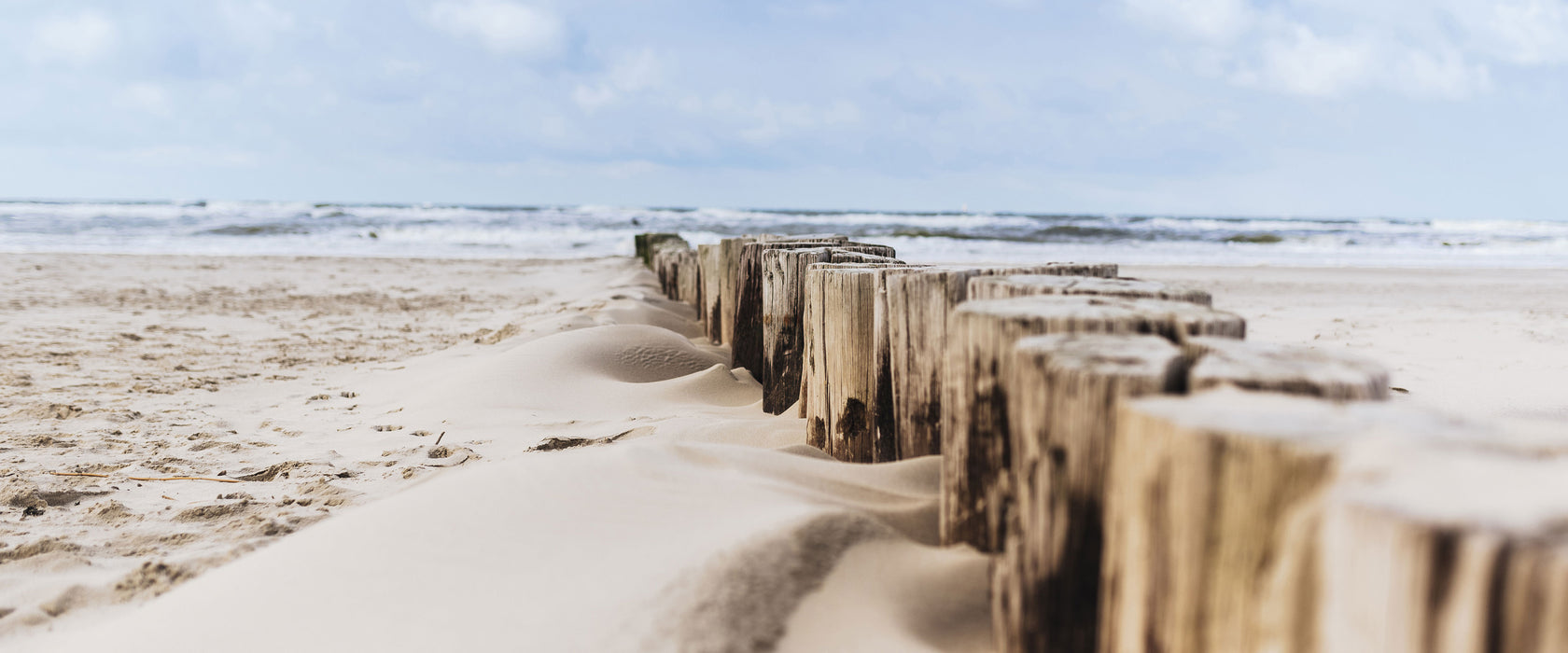 Nahaufnahme Steg aus Holzpföcken am Meer, Glasbild Panorama