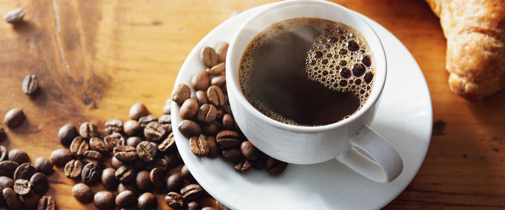 Tasse Kaffee mit Bohnen und Croissant, Glasbild Panorama