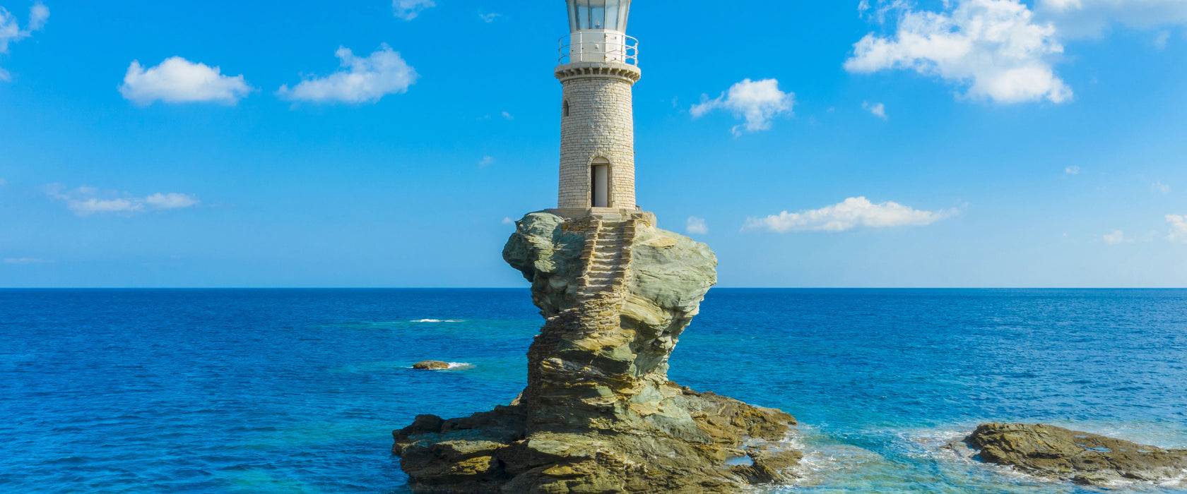 Leuchtturm auf kleiner Insel im Meer, Glasbild Panorama