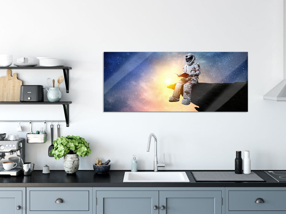 Lesender Astronaut auf Vorsprung vor Galaxie, Glasbild Panorama