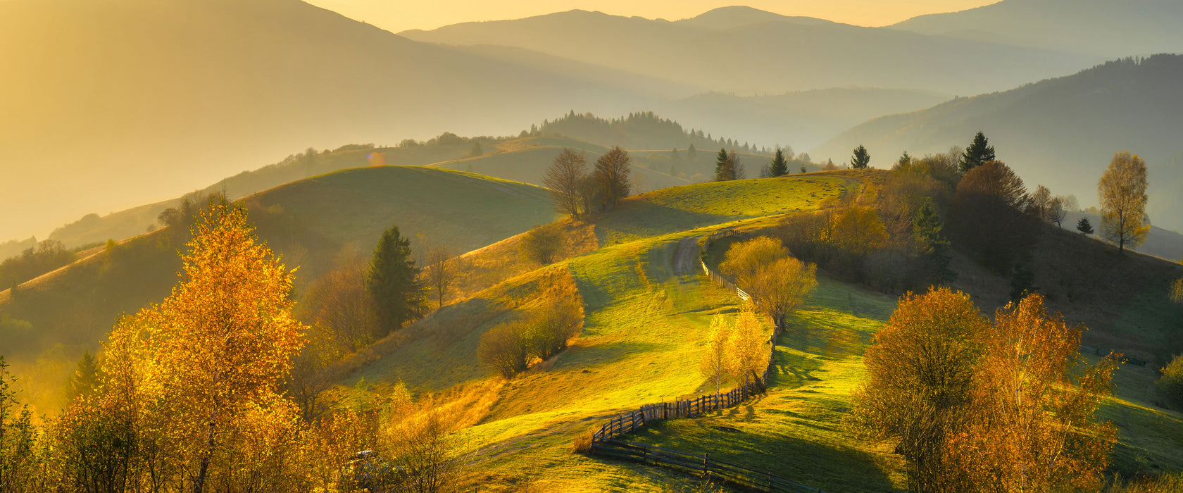 Hügelige Herbstlandschaft bei Sonnenuntergang, Glasbild Panorama