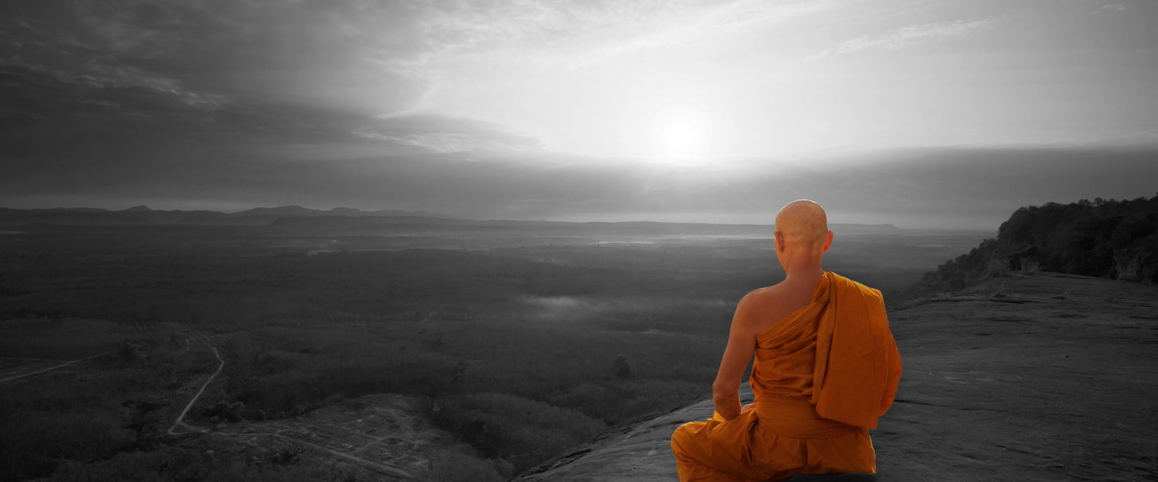 Mönch meditiert auf Felsvorsprung B&W Detail, Glasbild Panorama
