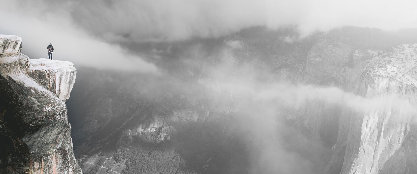 Einsamer Wanderer auf Felsklippe B&W Detail, Glasbild Panorama