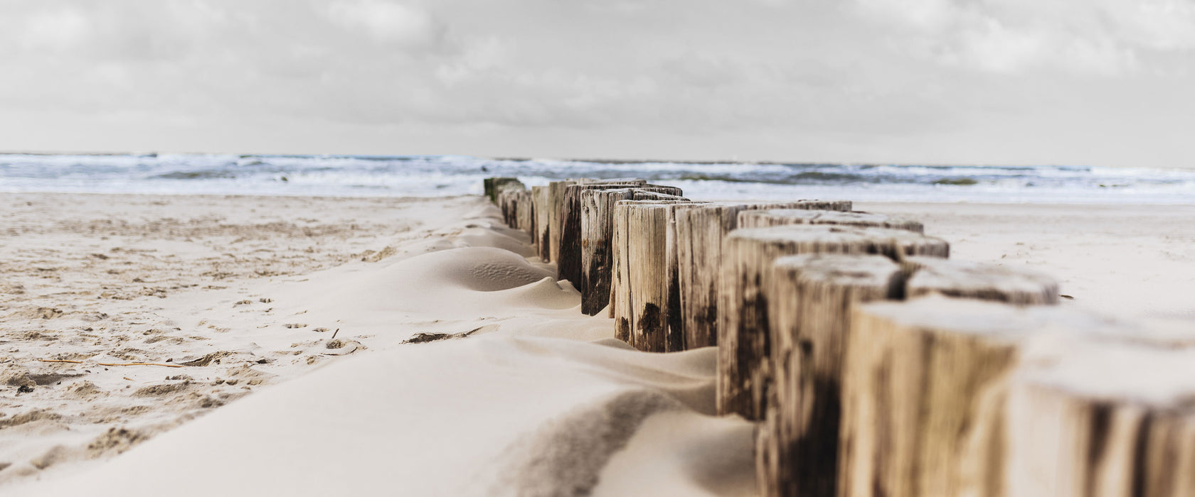 Nahaufnahme Steg aus Holzpföcken am Meer B&W Detail, Glasbild Panorama