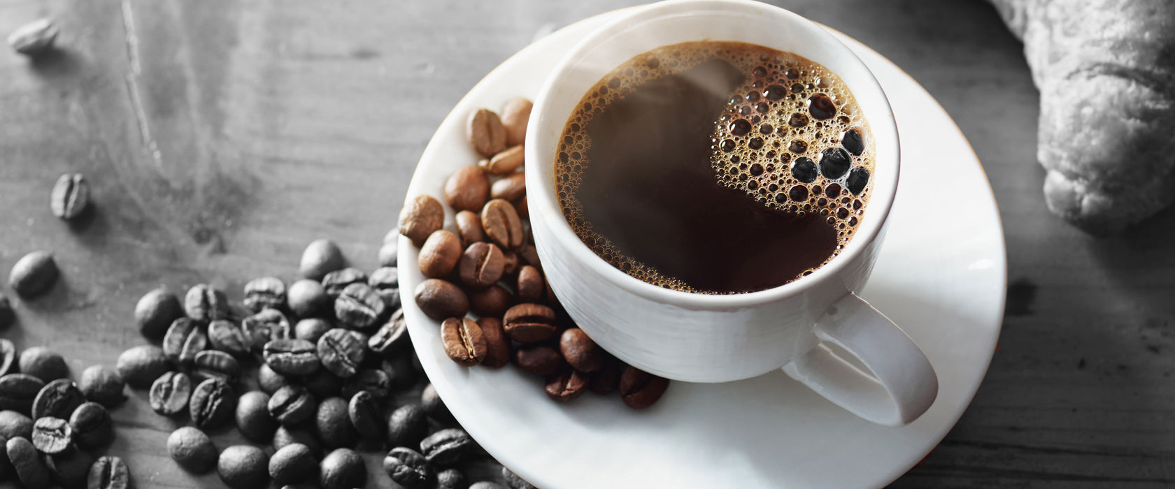 Tasse Kaffee mit Bohnen und Croissant B&W Detail, Glasbild Panorama