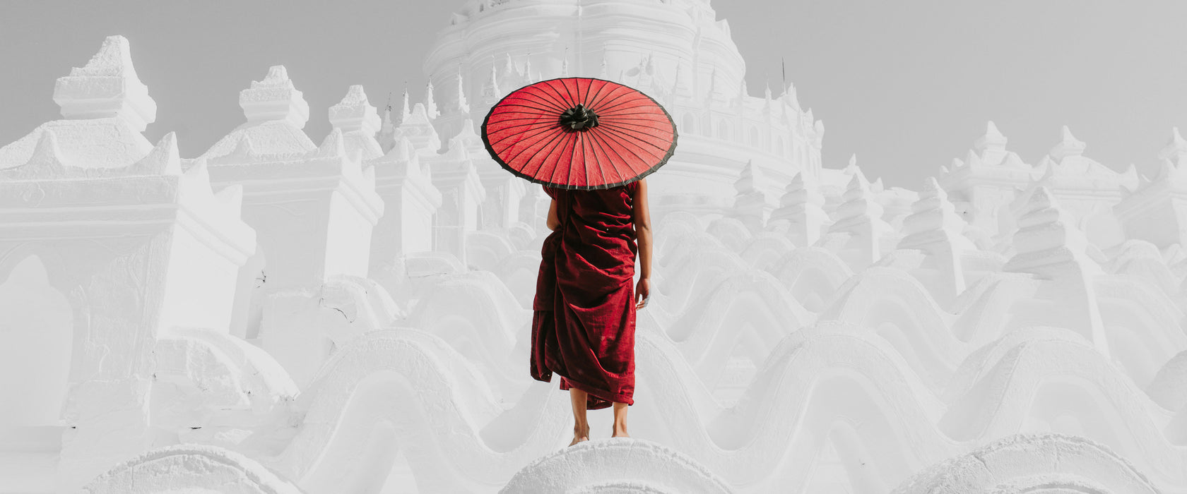 Mönch in rotem Gewand vor weißem Tempel B&W Detail, Glasbild Panorama