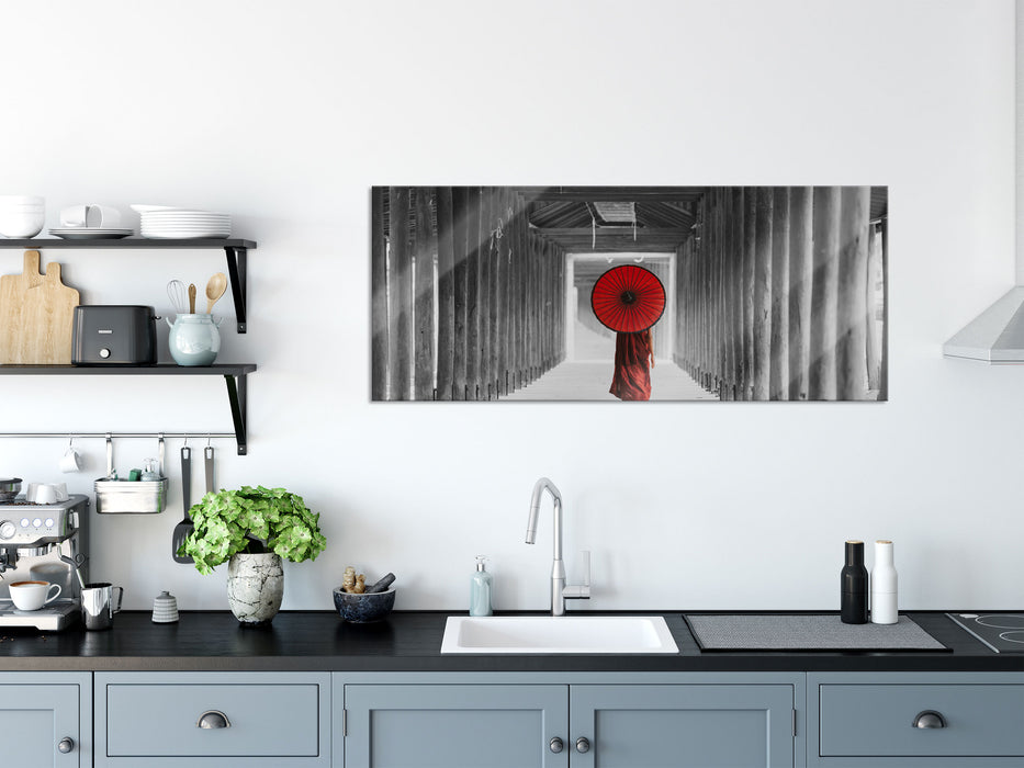 Mönch mit rotem Schirm im Tempelgang B&W Detail, Glasbild Panorama