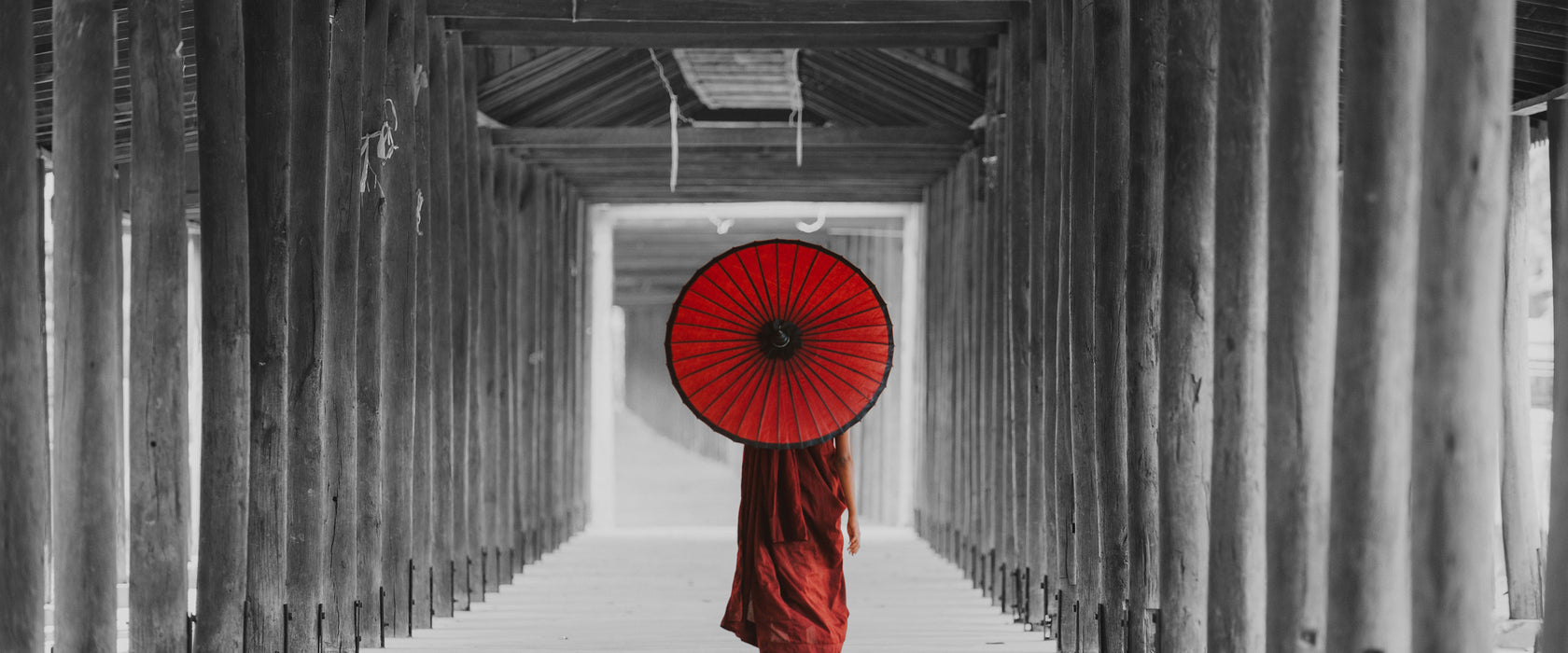 Mönch mit rotem Schirm im Tempelgang B&W Detail, Glasbild Panorama