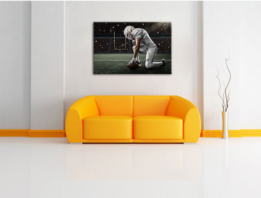 knieender Football-Spieler Leinwandbild über Sofa