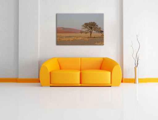 einzelner Baum in Wüste Leinwandbild über Sofa